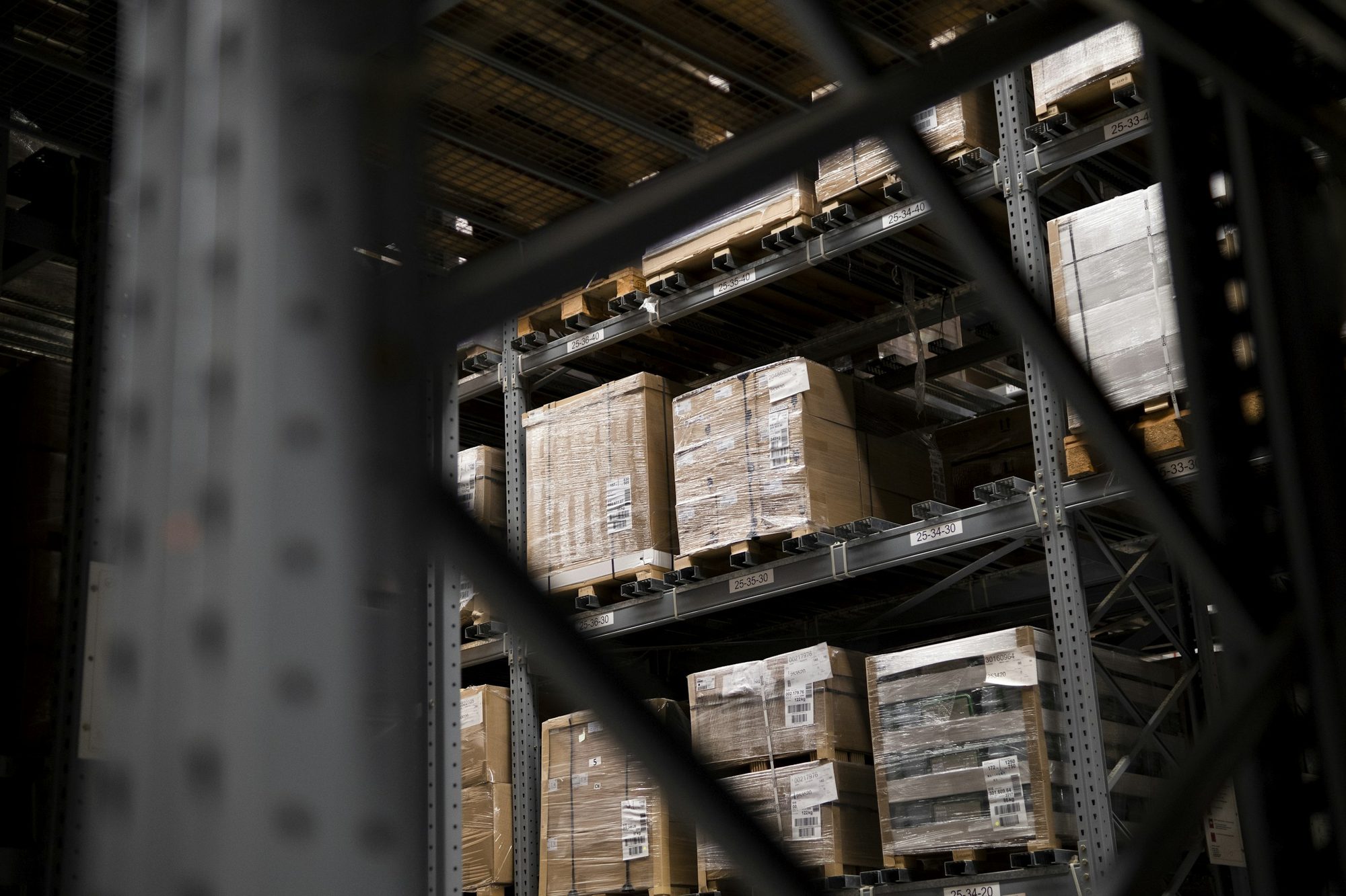 Stretch-wrapped pallets of boxed goods on warehouse racking